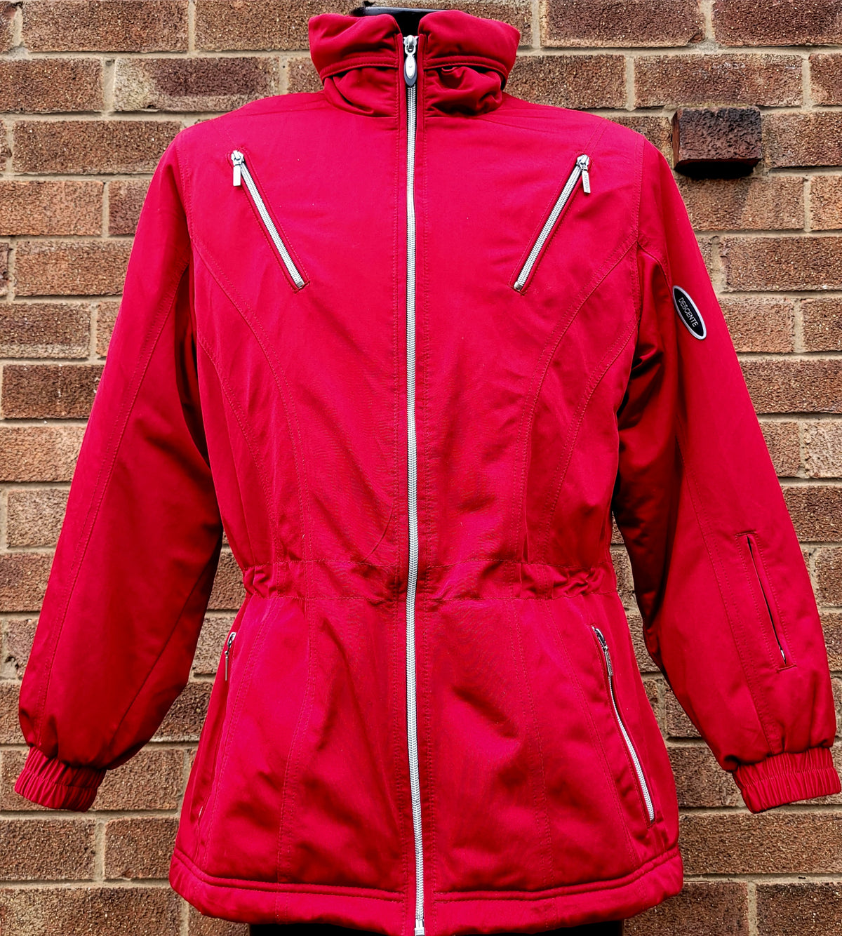 Vintage Descente women's red insulated ski jacket with full zip front, high funnel neck, multiple zip pockets, sleeve logo badge and tailored alpine fit.